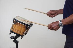 Man is beating bongo drums. Concept, musical percussion instrument for rhythm of music to make more fun for performing or dancing. Beat drum with rhythm along music and songs. photo