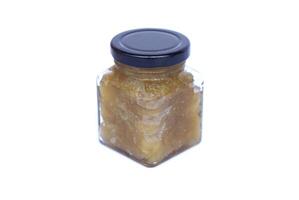 Glass jar of homemade mango jam in natural color, isolated on white background. Concept, fruit processing and food preservation,reducing food waste and extending shelf life naturally. photo