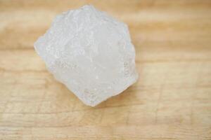 Alum stones on wooden floor background. Thais use it to get rid of body odor and swing the dirty water to make water clear. Useful for beauty and spa treatment. Use to treat cracked heels photo