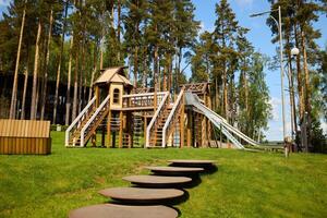 A Beautiful Wooden Playground Structure Nestled Amongst the Lush Trees in Natures Embrace photo