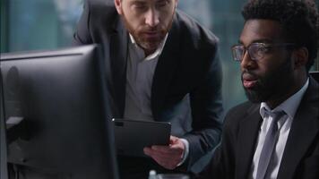 Two diverse coworkers African American Caucasian men talking discussing project looking analyzing computer startup pc males guys business businessmen office employers multiethnic colleagues teamwork video