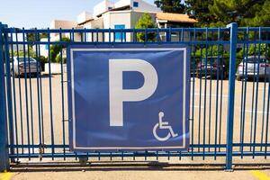 Parking sign on blue gate. Urban accessibility, transportation regulation, and inclusive infrastructure in public spaces photo
