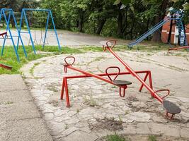 Colorful seesaws and swings in an empty outdoor playground. A quiet urban space for children's play and recreation. photo