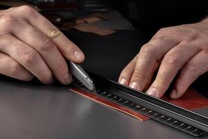 The process of making leather goods The hands of the master work with a leather product. photo