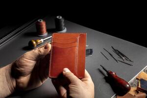 The process of making leather goods The hands of the master work with product. photo
