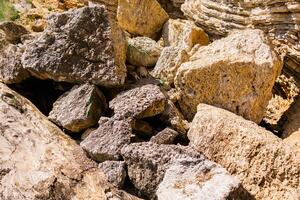 Broken limestone blocks scattered across a rocky slope. Natural erosion, geology, and raw mineral texture in an outdoor setting. photo