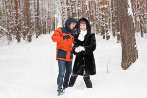 Couple having fun in winter park on a bright day laughing and smiling photo