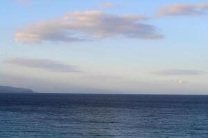 Blue sea and sky with clouds in sunset light. Nature composition. photo