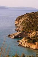 Blue Sea, island and mountains on the horizon photo