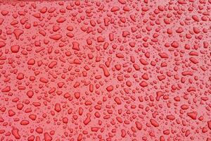 Rain droplet on red surface. Background or texture. photo
