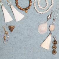Handmade white and bronze jewelry on the gray woolen background photo