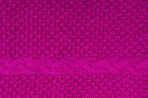 Top view of handmade bright fuchsia knitted texture with plait photo