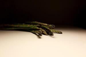 Fresh Green Asparagus Spears on White Table with Minimal Background photo