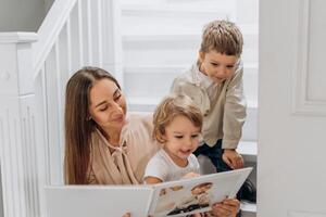 Mother and her two sons sit together sharing tablet time while enjoying quiet focused communication in honor of World Listening Day building emotional intelligence and family closeness naturally photo