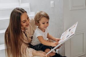Mother and little child enjoy quiet time together reading from a photo album on National Day of Unplugging sharing smiles warmth and undistracted connection during simple everyday moments