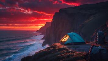 Camping on Cliffside Overlooking Ocean at Dramatic Sunset with Backpacks photo