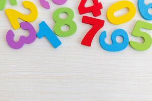 Colorful Wooden Numbers on Light Wood Background photo