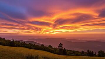 Sweeping sunset illuminates vast, layered mountainous terrain densely forested. photo
