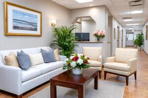 Elegant waiting room with comfortable furniture and flower bouquets photo