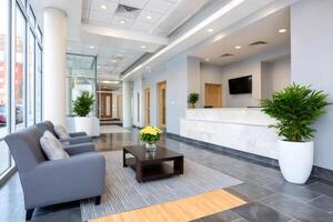 Modern office lobby with reception desk and waiting area featuring comfortable seating photo
