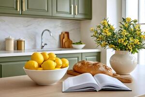 Lemons, bread and open book resting on kitchen table photo