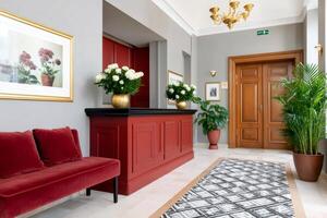 Elegant hotel lobby with red reception desk and patterned carpet photo