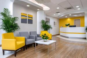 Modern waiting room with yellow and gray armchairs and reception desk photo