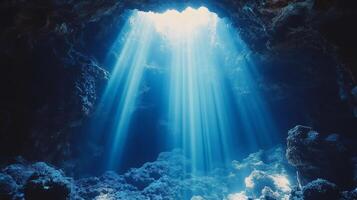 Underwater cave with sunbeams shining through opening photo