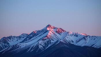 a mountain ridge lit by the first light of dawn. photo