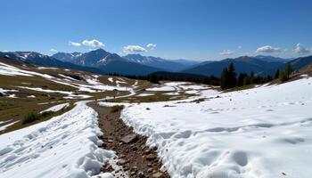 a quiet alpine pass with patches of snow and grass. photo