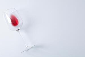 Glass with red wine on grey background, space for text photo