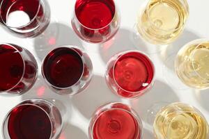 Glasses with different wine on white background, closeup and top view photo