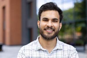 A young, smiling student poses for the camera, showcasing a confident and friendly expression, outdoors with a building. photo