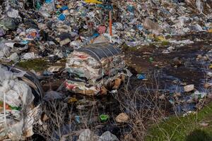 Piles of plastic and garbage fill a landfill area, showcasing the ongoing struggle with pollution and environmental impact on ecology photo