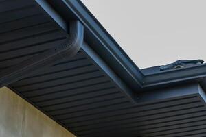 Unique metallic roof design features sleek tiles and efficient guttering, showcasing modern roofing techniques in residential architecture photo
