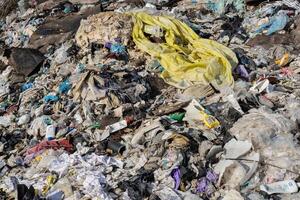 A landfill overflowing with discarded plastic, clothes, and garbage highlights the urgent need for better waste management and recycling practices photo