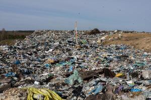 Large landfill area overflowing with trash, plastic debris, and waste impacting the local ecosystem and sanitation efforts photo