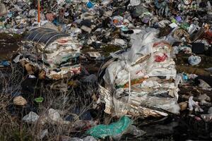 A large landfill is overflowing with plastic, trash, and various debris, highlighting the pollution problem affecting the local ecology photo