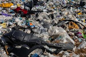 Plastic debris and garbage cover the landfill, highlighting issues of pollution and the need for effective recycling solutions photo