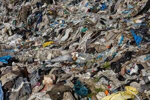 A vast expanse of mixed trash and debris covers a landfill, highlighting environmental challenges and the impact of waste accumulation photo
