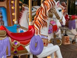 Vibrant carousel horses stand proudly, featuring detailed craftsmanship and bright colors while visitors enjoy the cheerful atmosphere photo