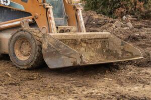 A construction vehicle is actively moving and leveling dirt at a site, contributing to the groundwork for future development photo