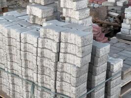 Piled concrete blocks and patterned stones are organized neatly at a busy construction site, ready for building projects photo