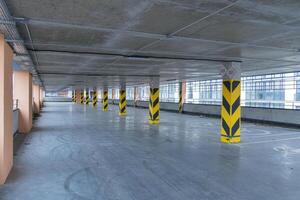 Spacious parking structure features minimal vehicles and marked columns, showcasing clean lines and industrial architecture photo