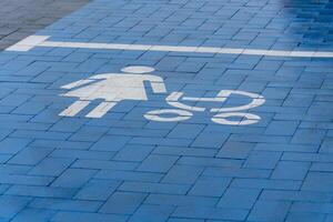 A blue parking space features a clear symbol indicating it is reserved for parents with strollers, promoting convenience photo
