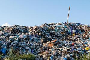 A massive heap of trash cluttered with plastic stands out under the blue sky, highlighting major waste management problems photo