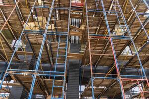 Workers navigate complex scaffolding structures as construction progresses in a busy urban area during midday photo