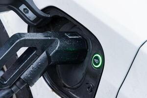 Electric car connects to a charging station, highlighting advancements in transportation and the shift towards renewable energy sources photo