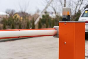 An automatic gate stands closed at a parking lot entrance, designed for security and controlled access, promoting safe vehicle entry photo