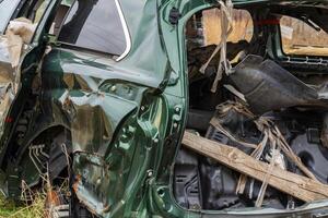 A severely damaged vehicle lies in a field after a crash, illustrating the tragic results of road accidents and the need for safety photo
